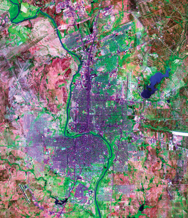Laredo, Texas (east of the Rio Grande river) and Nuevo Laredo, Taumalipas (west of the river). Blue, water; green, vegetation; blue-violet, roads and buildings; blue-violet areas on the western side of Nuevo Laredo, low-income neighborhoods; pink, land with little or no vegetation. (National Aeronautics and Space Administration (NASA)/U.S. Geological Survey LANDSAT 7 image [TM bands 7, 4, and 3];courtesy of NASA.)