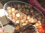 Thumbnail of Photograph taken at a local street market in Gabon shows a lizard in a basket of onions, which are frequently eaten uncooked. Salmonella enterica subspecies enterica serotype Agama has been isolated from lizards in Africa.