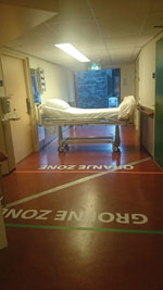 Thumbnail of Entrance of isolation unit with demarcated zones, Major Incident Hospital, University Medical Centre of Utrecht, the Netherlands, 2014. Markings on the floor indicate a safe zone and potentially contaminated zones and delineate doffing zones (where potentially contaminated clothing and gear are removed) for ambulance and disinfection personnel.