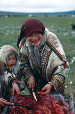 Thumbnail of A Khanty mother and her child eating raw reindeer meat in the Yamal Peninsula (Yamalo-Nenets Autonomous Okrug), northern Siberia, Russia, 1991. Photograph courtesy of Marianna Flinckenberg-Gluschkoff.
